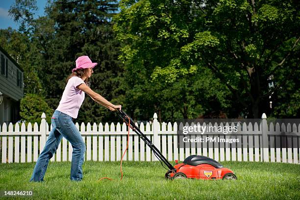 woman mowing lawn - handgrasmaaier stockfoto's en -beelden