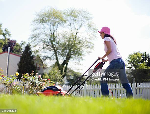 woman mowing lawn - cortacésped manual fotografías e imágenes de stock