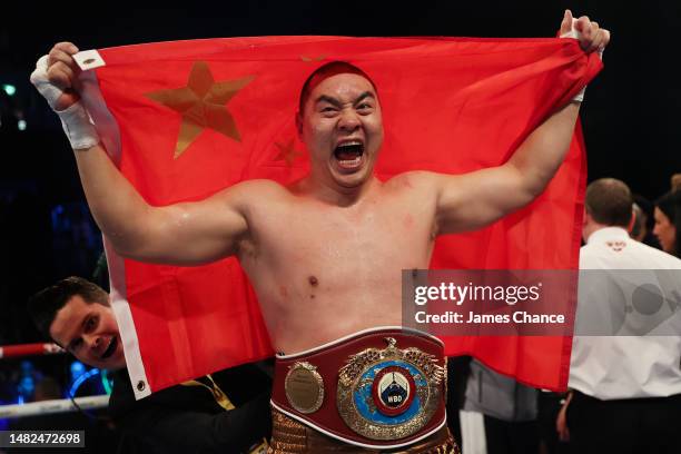 Zhilei Zhang celebrates victory while holding the Chinese flag and wearing the WBO Interim World Heavyweight belt following the WBO Interim World...