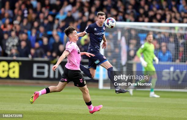 Paul Huntington of Carlisle United heads the ball clear of Kieron Bowie of Northampton Town during the Sky Bet League Two between Carlisle United and...