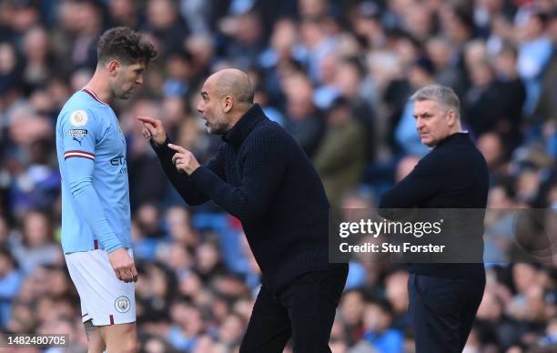 Manchester City head coach Pep Guardiola reacts on the sidelines with defender John Stones during the Premier League match between Manchester City...