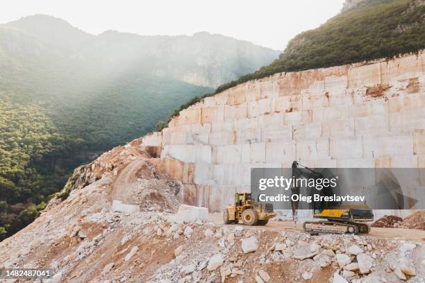 open pit stone mining in mountains. marble and granite quarry aerial view - bulldozer stock pictures, royalty-free photos & images