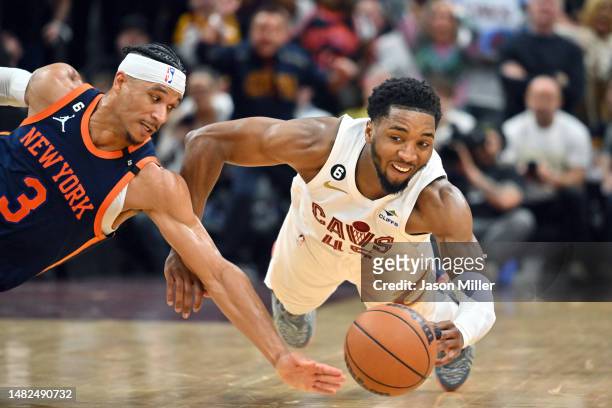 Josh Hart of the New York Knicks and Donovan Mitchell of the Cleveland Cavaliers dive for a loose ball during the fourth quarter of Game One of the...