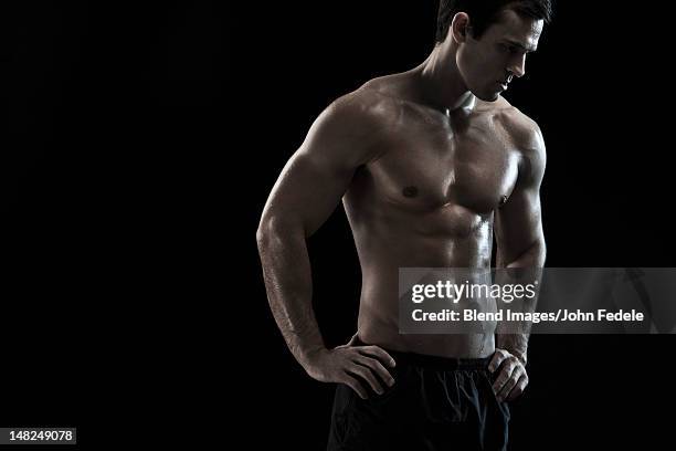 bare chested caucasian man with hands on hips - john hale stock pictures, royalty-free photos & images