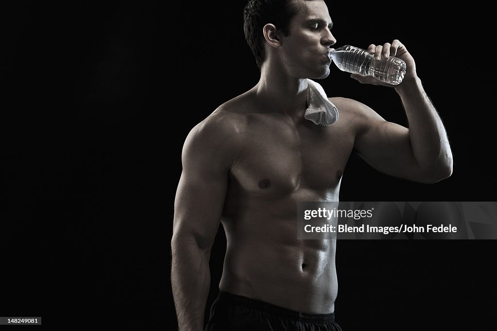 Caucasian man drinking water after exercise