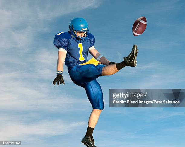 caucasian football player kicking football - american football fotografías e imágenes de stock
