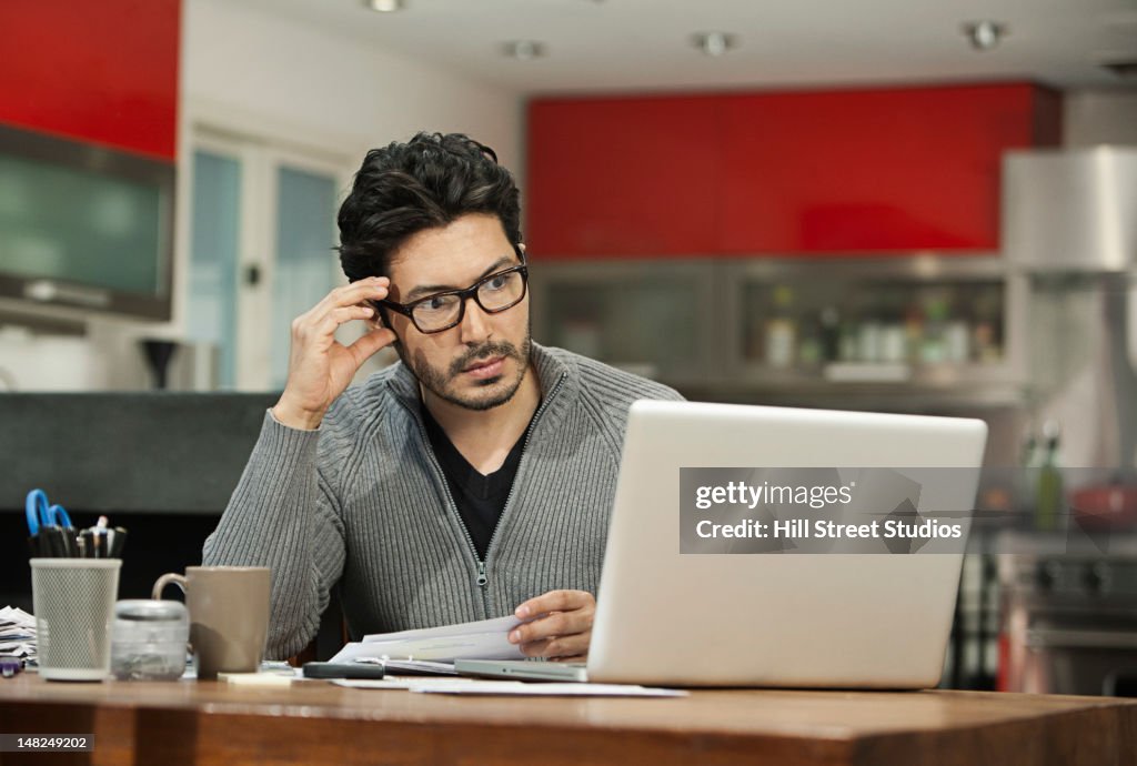 Hispanic man paying bills on computer