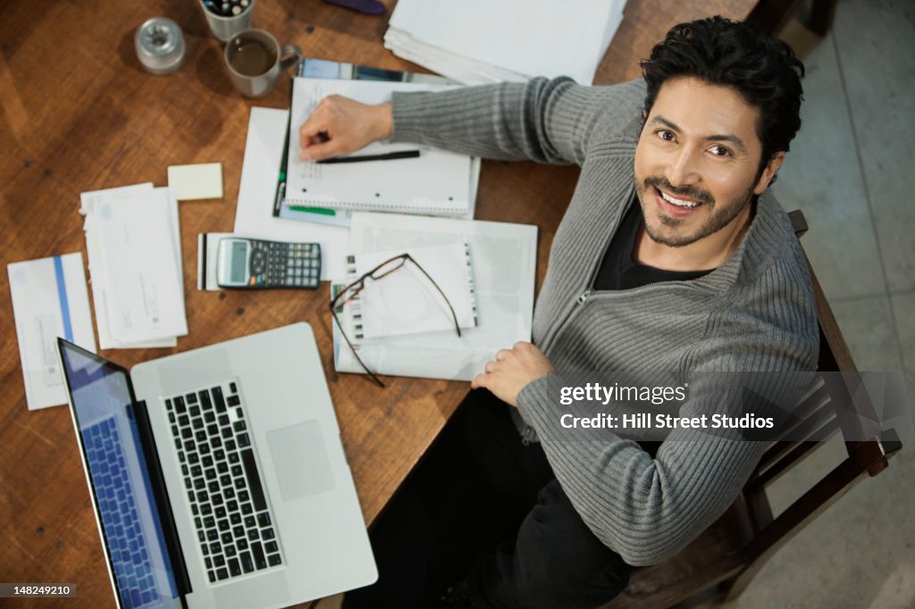 Hispanic man paying bills on computer