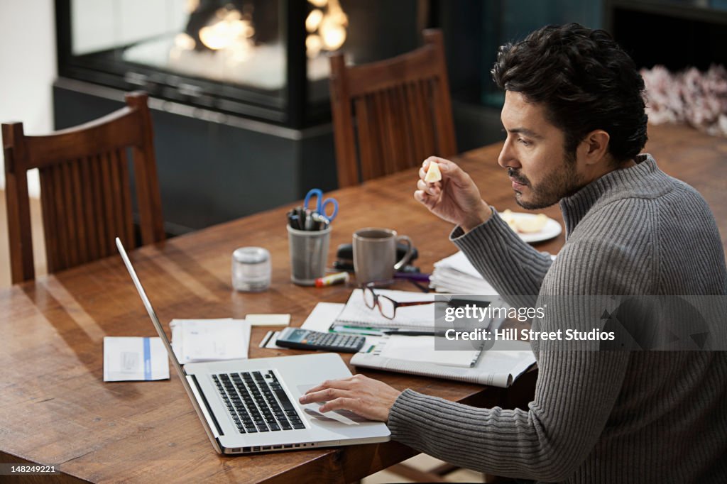 Hispanic Mann, die Noten auf dem computer