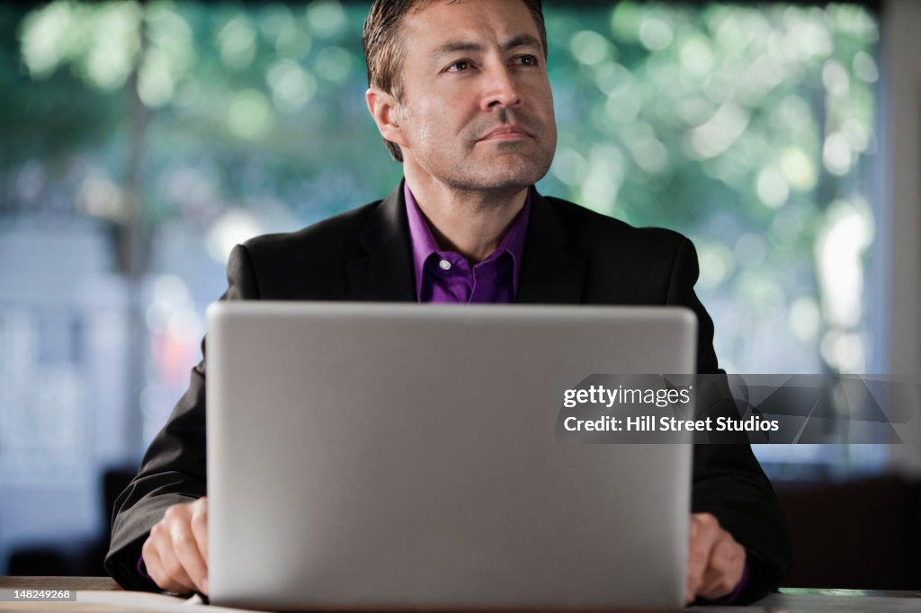 Hispanic businessman using laptop