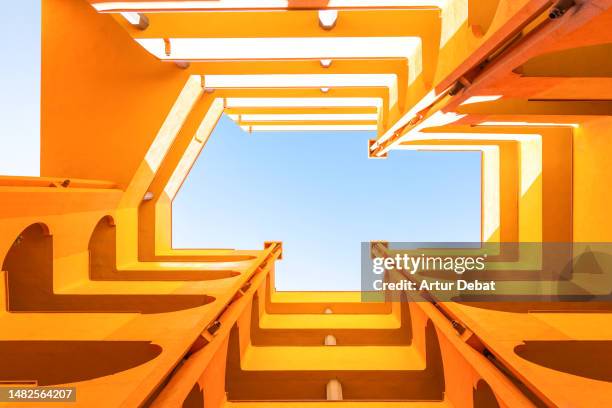 visual yellow architecture with inner courtyard lightwell from directly below, blue sky and creative perspective. - hoek beschrijvende begrippen stockfoto's en -beelden