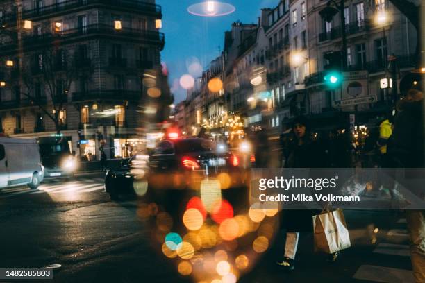 Going out, street lights twinkle in a wine glass, 2023 in Paris, France. Famous for its iconic landmarks, Paris is considered one of the most...