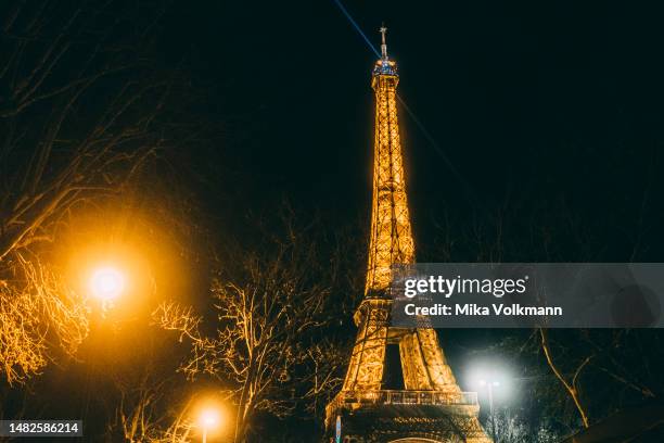 Eiffel tower at night with lights, 2023 in Paris, France. Famous for its iconic landmarks, Paris is considered one of the most beautiful and romantic...