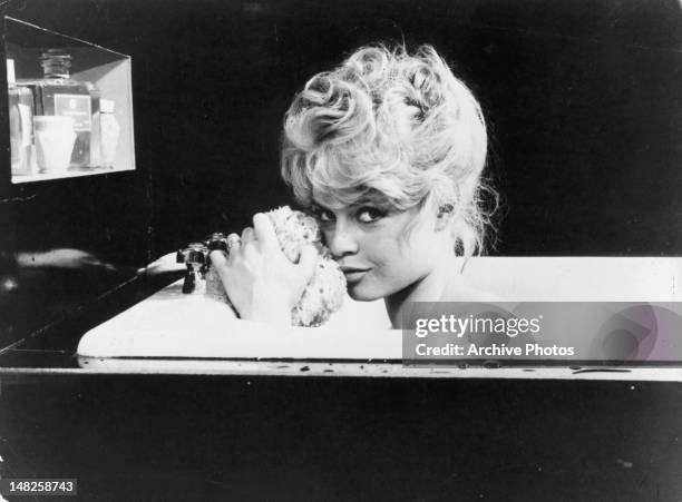 Brigitte Bardot in the bathtub with an seductive look on her face in a scene from the film 'La Parisienne', 1957.