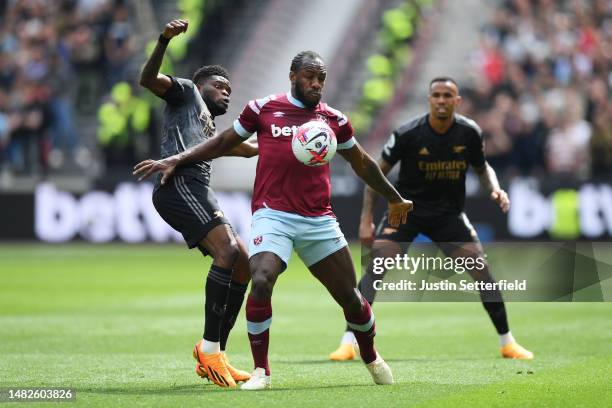 Michail Antonio of West Ham United battles for possession with Thomas Partey of Arsenal during the Premier League match between West Ham United and...