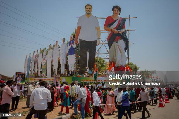 Supporters walk next to giant cutouts of Indian National Congress leaders Rahul Gandhi and his sister Priyanka Vadra as they arrive to attend an...