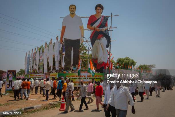 Supporters walk next to giant cutouts of Indian National Congress leaders Rahul Gandhi and his sister Priyanka Vadra as they arrive to attend an...