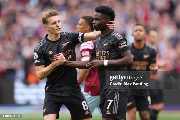 Martin Odegaard consoles teammate Bukayo Saka of Arsenal after missing a penalty during the Premier League match between West Ham United and Arsenal...