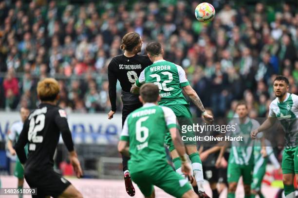 Lucas Hoeler of Sport-Club Freiburg scores the team's second goal whilst under pressure from Marco Friedl of SV Werder Bremen during the Bundesliga...