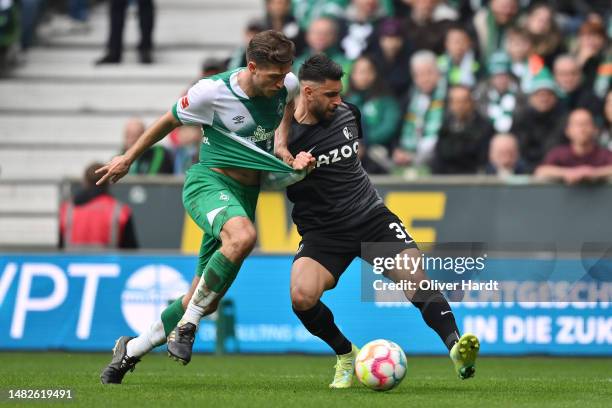 Niklas Stark of SV Werder Bremen battles for possession with Vincenzo Grifo of Sport-Club Freiburg during the Bundesliga match between SV Werder...