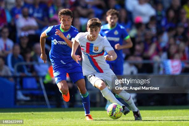 Gavi of FC Barcelona runs with the ball whilst under pressure from Luis Milla of Getafe CF during the LaLiga Santander match between Getafe CF and FC...