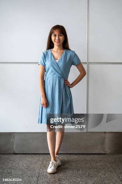 full length front view image of asian woman wearing blue turquoise dress with wall background - cut out dress stock pictures, royalty-free photos & images