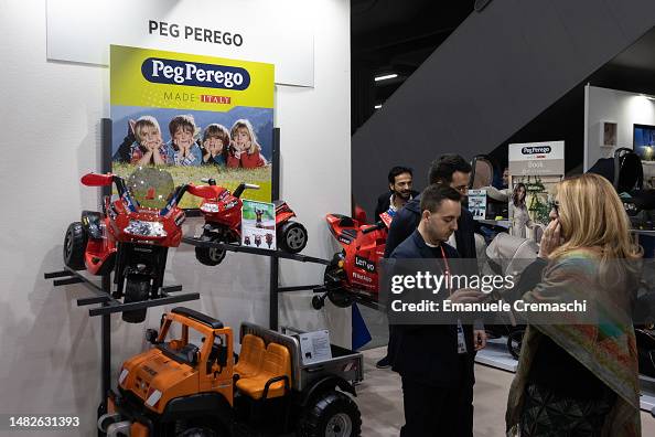 Perego Italy Fairgoers visit the Italian manufacturer Peg Perego display stand ...