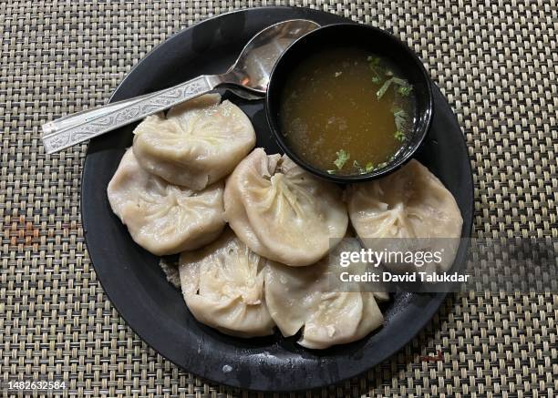 plate full of momo with soup - raviolis chinos fotografías e imágenes de stock