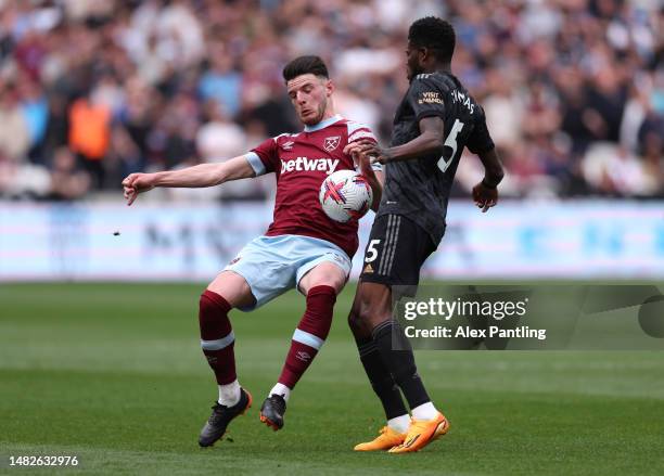 Declan Rice of West Ham United appears to handle the ball ahead of Thomas Partey of Arsenal in the build up for the first West Ham goal during the...