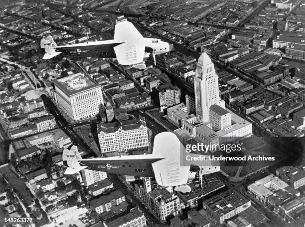An aerial view of Los Angeles with two Fokker monoplanes owned by Western Air Express flying over the recently completed City Hall, Los Angeles,...