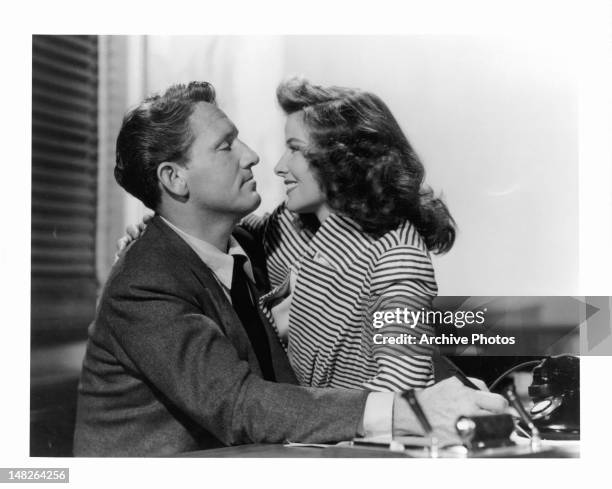 Katharine Hepburn sitting on Spencer Tracy's lap in his office in a scene from the film 'Woman Of The Year', 1942.