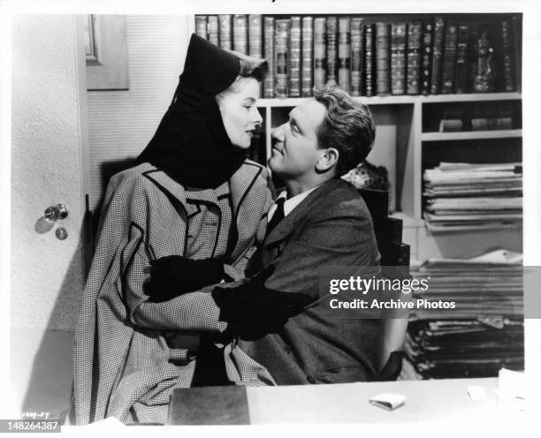 Katharine Hepburn sitting on Spencer Tracy's lap in a scene from the film 'Woman Of The Year', 1942.