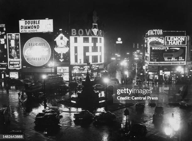 High-angle view of traffic on the road around the Shaftesbury Memorial Fountain and statue of Anteros silhouetted against the illuminated advertising...