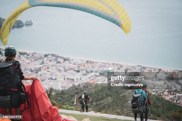 die menschen bereiten sich darauf vor, mit dem gleitschirmfliegen auf dem alanya-hügel zu fliegen - hang parachute stock-fotos und bilder