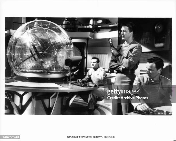 Jack Kelly, Leslie Nielsen, and Richard Anderson looking at forward as transparent orb in a scene from the film 'Forbidden Planet', 1956.