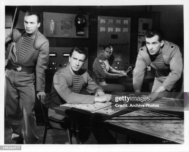 Warren Stevens, Leslie Nielsen, Richard Anderson, and Jack Kelly all looking in the same direction in control room in a scene from the film...