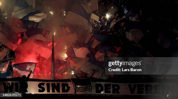 Fans of Berlin burn flares during the Bundesliga match between FC Schalke 04 and Hertha BSC at Veltins-Arena on April 14, 2023 in Gelsenkirchen,...