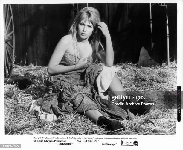 Scantily clad Margaret Blye sitting in hay in a scene from the stage play 'Waterhole', 1967.