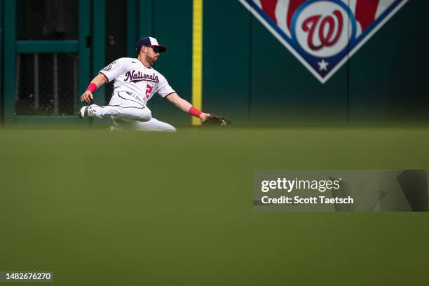 Lane Thomas of the Washington Nationals makes a sliding catch to retire Mike Zunino of the Cleveland Guardians during the ninth inning at Nationals...