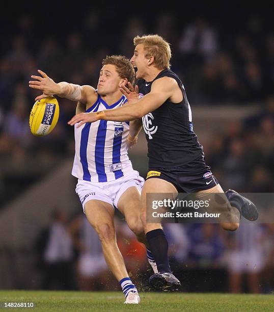Kieran Harper of the Kangaroos and Dennis Armfield of the Blues compete for the ball during the AFL Rd 16 game between North Melbourne and Carlton at...