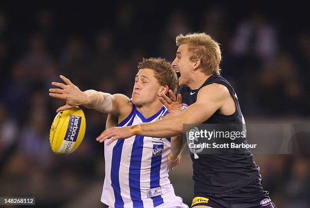 Kieran Harper of the Kangaroos and Dennis Armfield of the Blues compete for the ball during the AFL Rd 16 game between North Melbourne and Carlton at...