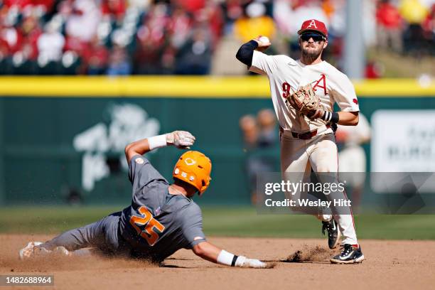 John Bolton of the Arkansas Razorbacks turns a double play at second against Blake Burke of the Tennessee Volunteers at Baum-Walker Stadium at George...