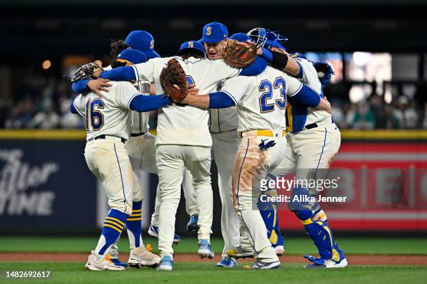 Kolten Wong, J.P. Crawford, Ty France, Cal Raleigh, Paul Sewald, and Eugenio Suarez of the Seattle Mariners dance after the game against the Colorado...