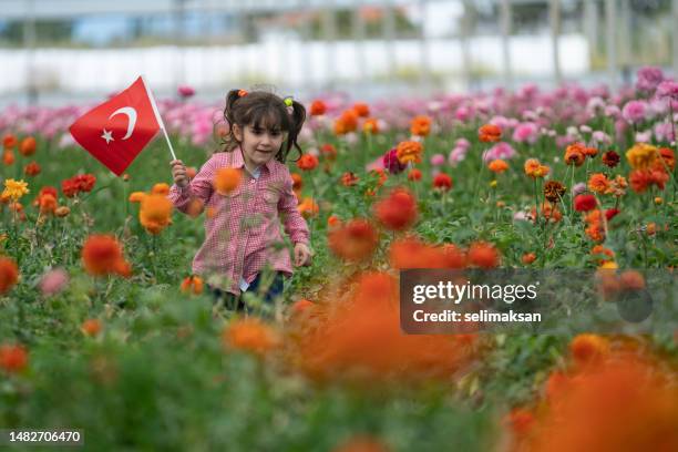 preschooler girl holding turkish flag in flower garden - april 5 stock pictures, royalty-free photos & images