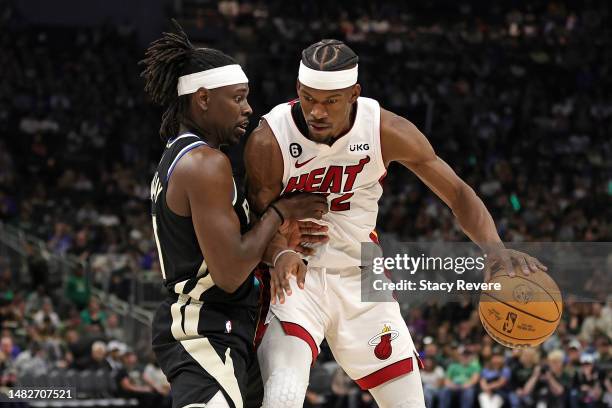 Jimmy Butler of the Miami Heat is defended by Jrue Holiday of the Milwaukee Bucks during the second half of Game One of the Eastern Conference First...