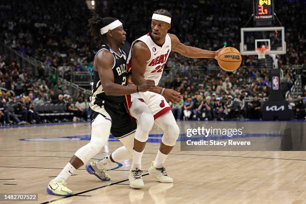 Jimmy Butler of the Miami Heat is defended by Jrue Holiday of the Milwaukee Bucks during the second half of Game One of the Eastern Conference First...