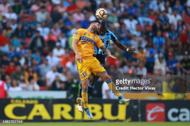 Andre Pierre Gignac of Tigres jumps for the ball with Kevin Balanta of Queretaro during the 15th round match between Querataro and Tigres UANL as...