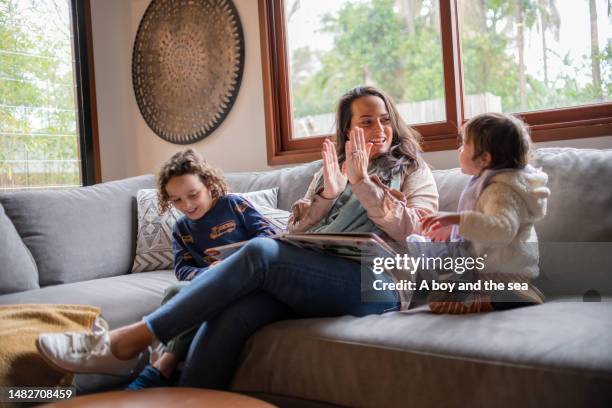 a mother enjoys sing along with her kids - australian family time stockfoto's en -beelden