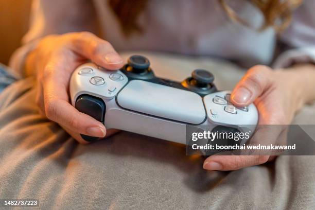 hands with handheld game controls. - brand name video game stockfoto's en -beelden