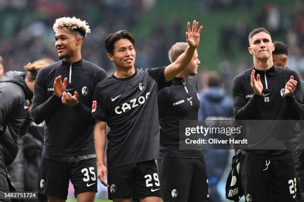 Tan Kenneth Jerico Schmidt and Wooyeong Jeong of Sport Club Freiburg applauds the fans after the Bundesliga match between SV Werder Bremen and...